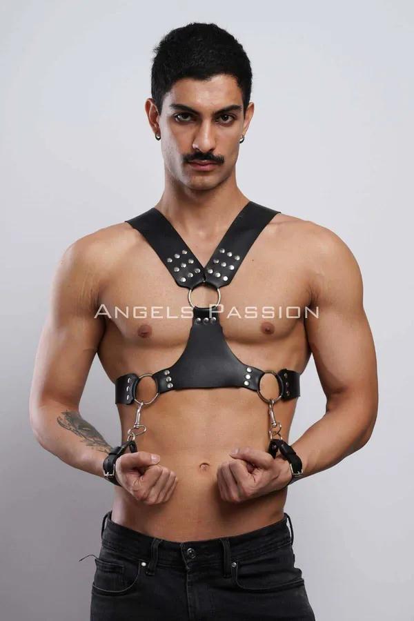 Black faux leather studded chest harness with three silver O-rings and detachable wrist cuffs worn by male model