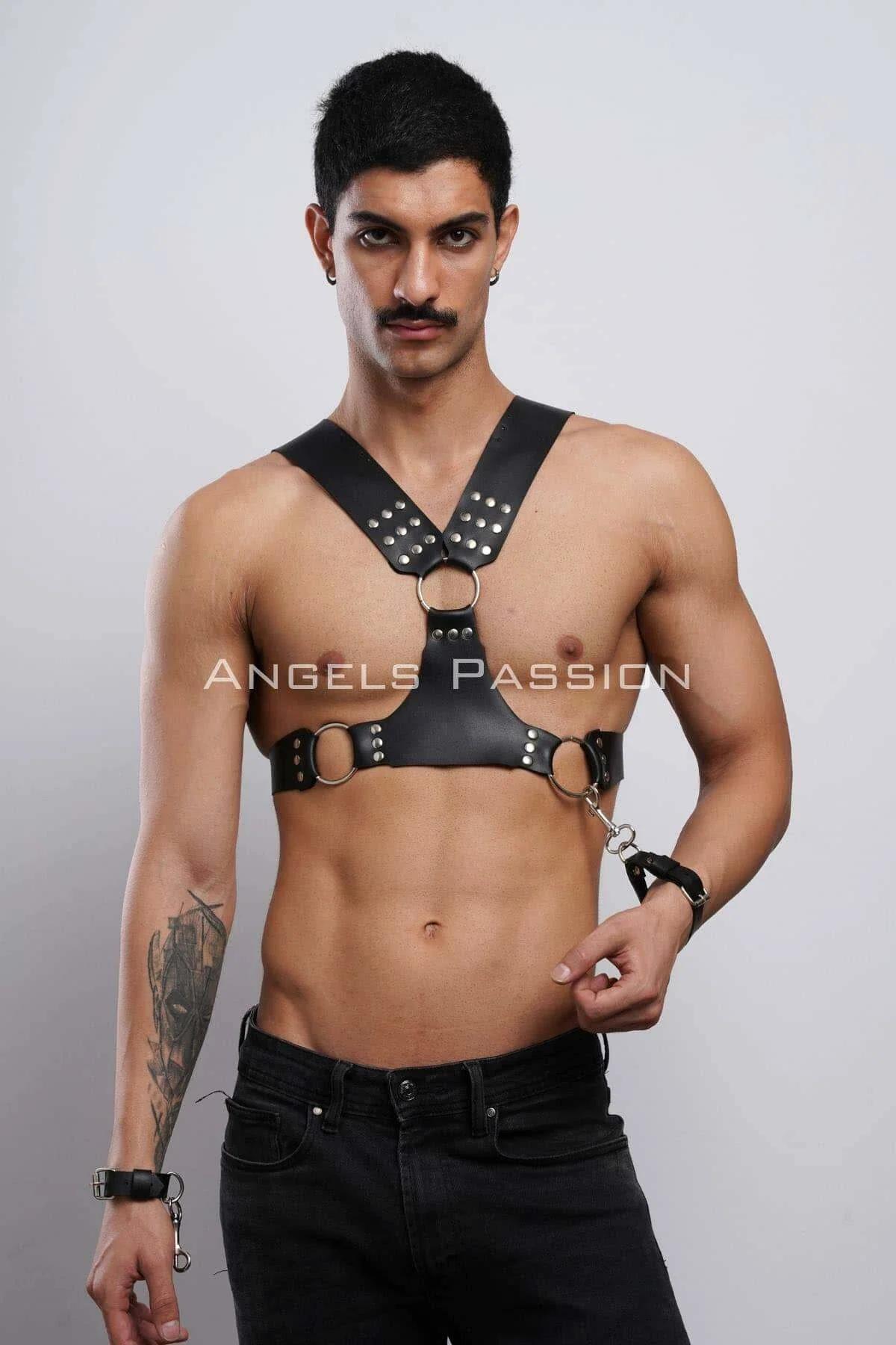 Close-up of silver dome studs and center O-ring on black faux leather chest harness