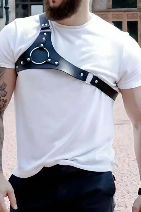 Black vegan leather O-ring shoulder harness on man over white T-shirt with silver dome studs