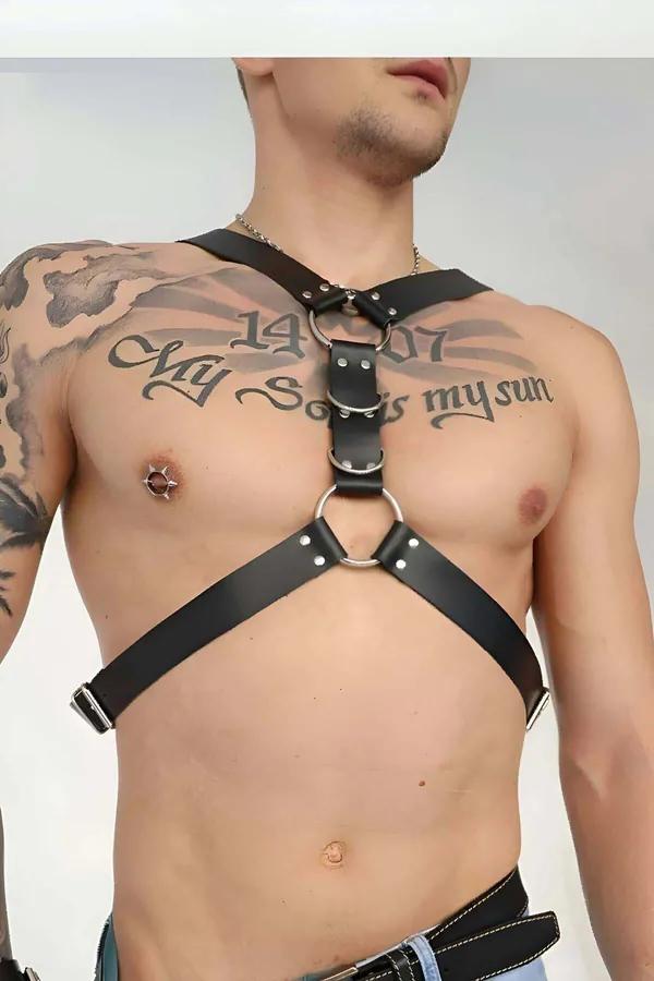 black faux leather adjustable O-ring chest harness with silver buckles worn by man with tattoos