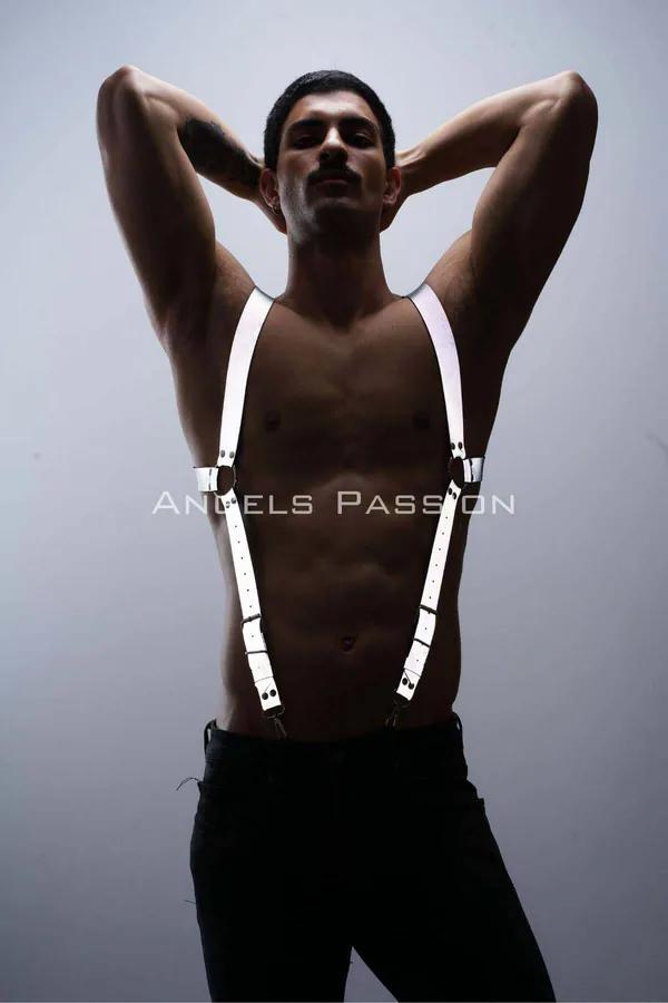 White reflective body harness with silver buckles worn by male model, suspender-style strap configuration over bare chest