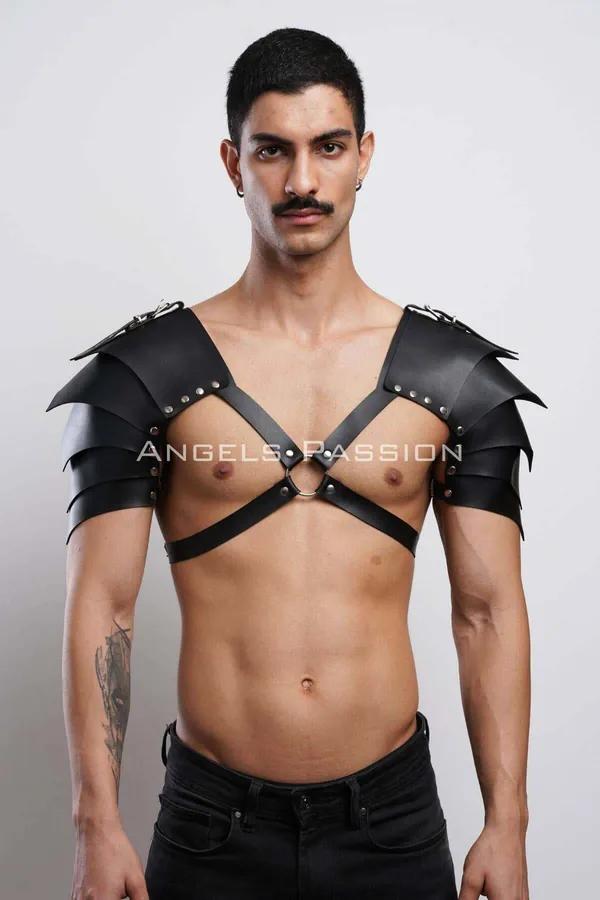 Black faux leather shoulder armor harness with layered pauldrons, silver studs, and central chest O-ring worn by male model