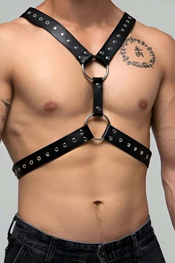 Black faux leather chest harness with dual silver O-rings and riveted straps worn by a male model
