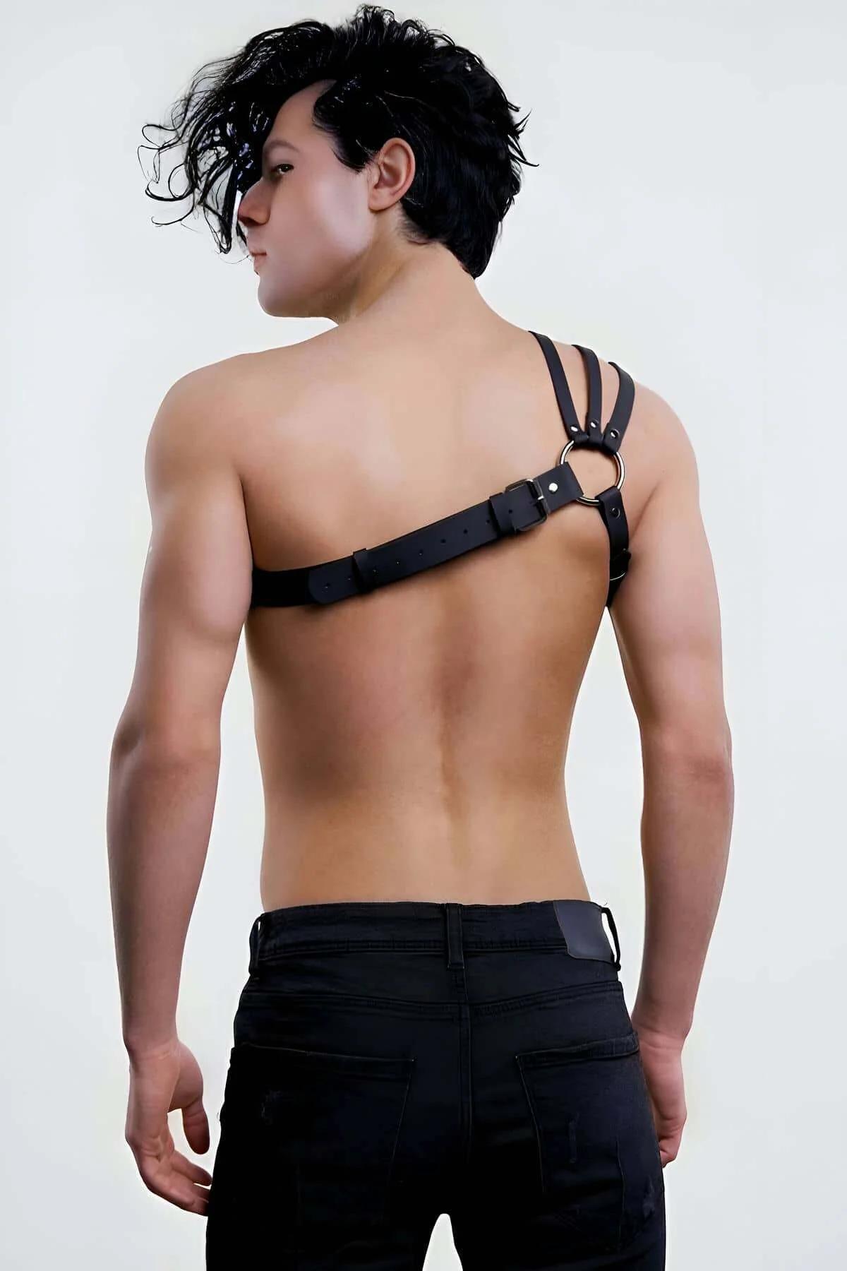Close-up of silver O-ring and double shoulder straps on black faux leather chest harness