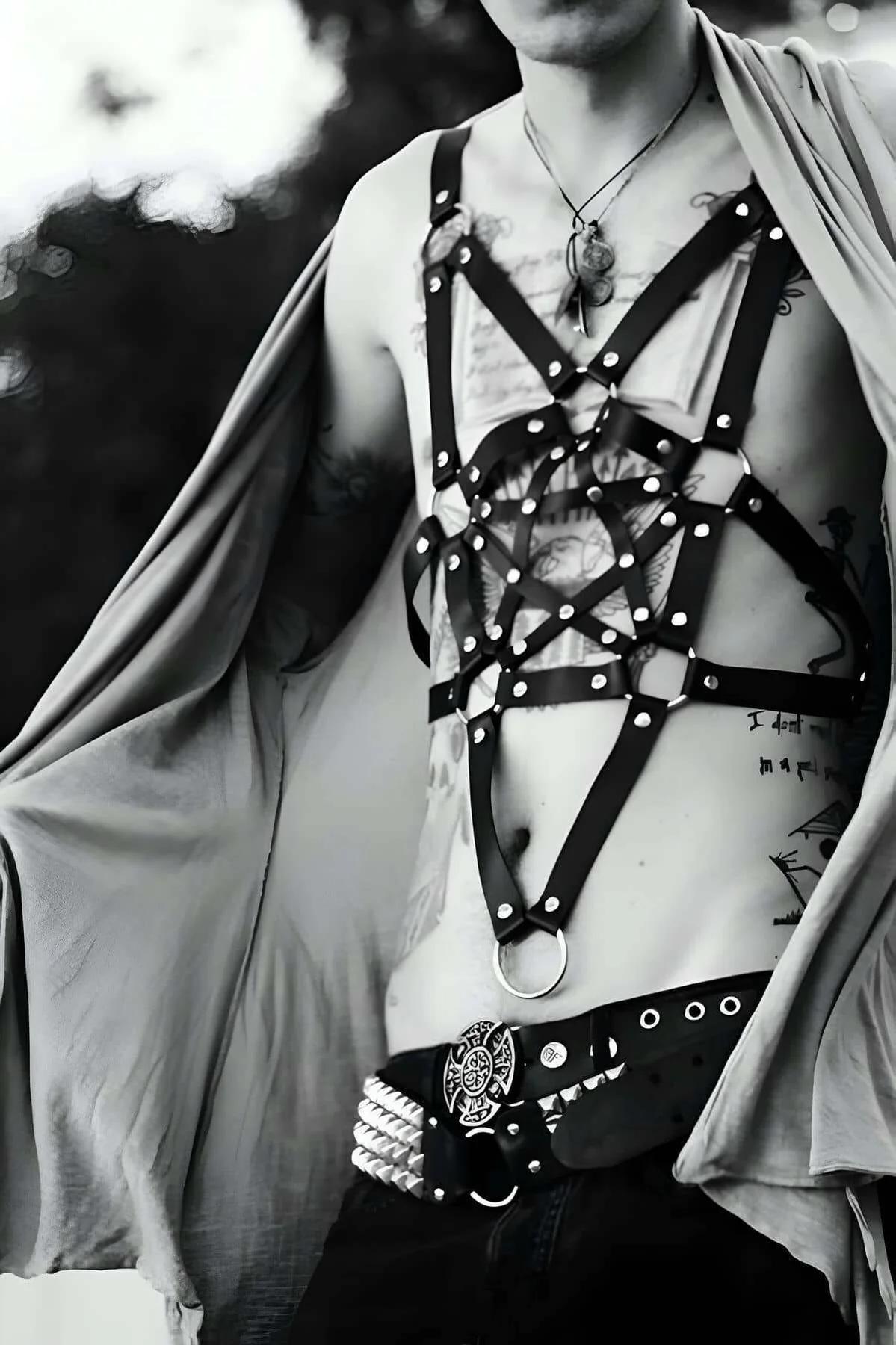 close-up of geometric star cage center panel with silver rivets and central O-ring on black faux leather harness