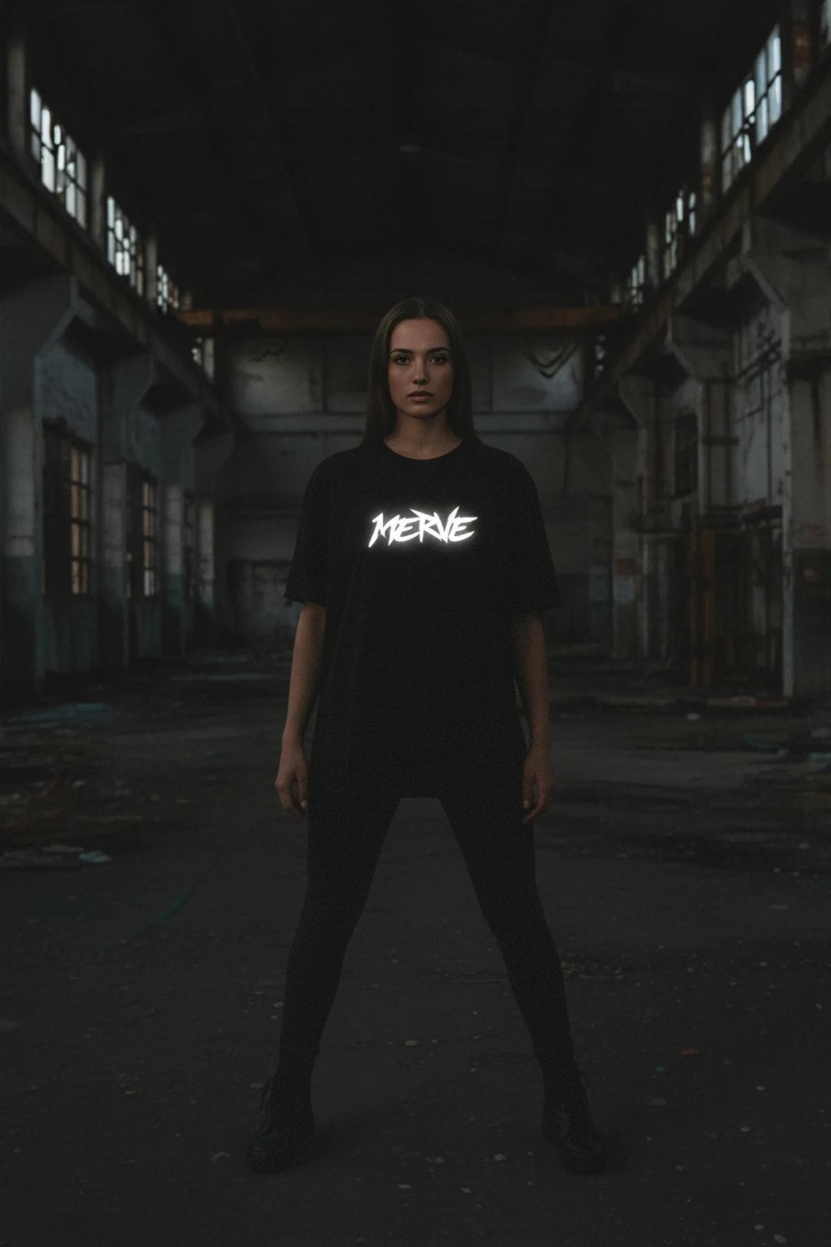 Black oversized men's T-shirt with white reflective graffiti logo printed at chest center, boxy dropped-shoulder fit