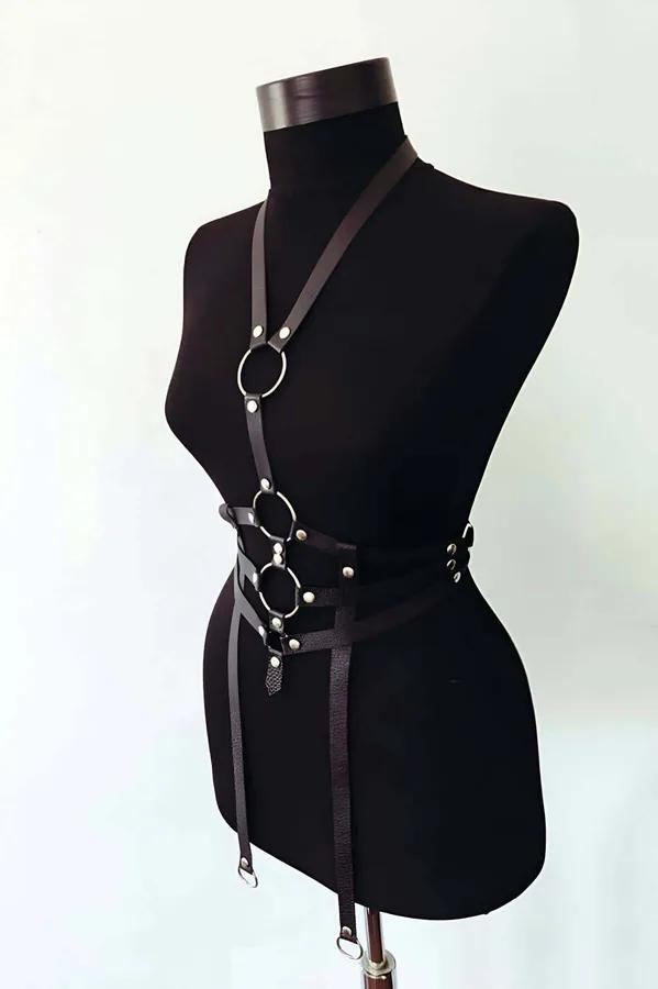 Black faux leather men's body harness with three stacked silver O-rings, single shoulder strap, and dual hip drop straps on m