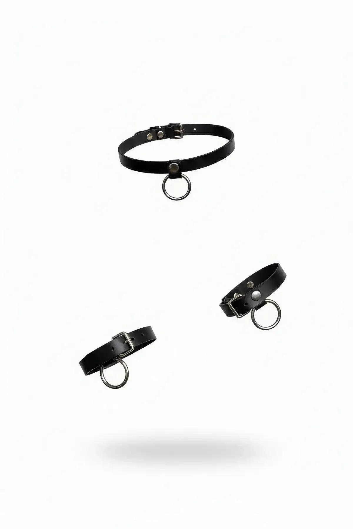 black faux leather choker and two wristbands set with silver O-ring buckle hardware on white background