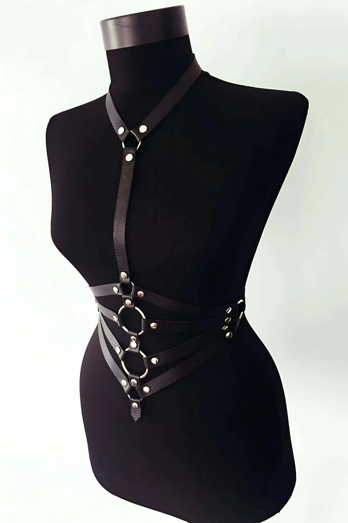 Black faux leather chest harness with three stacked hexagonal O-rings and silver rivet studs on mannequin
