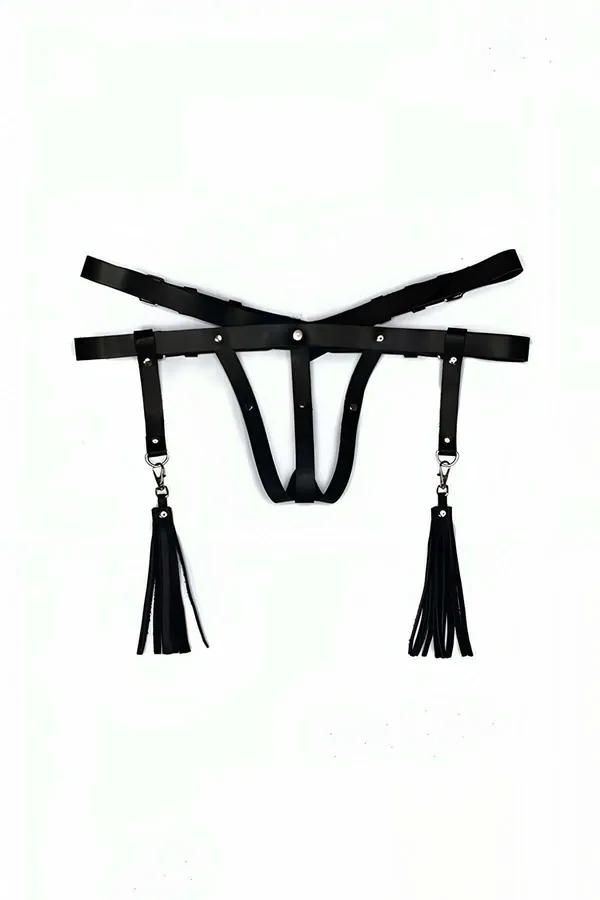 black faux leather thong harness with two detachable fringe tassels clipped to silver D-ring hip straps, flat lay view