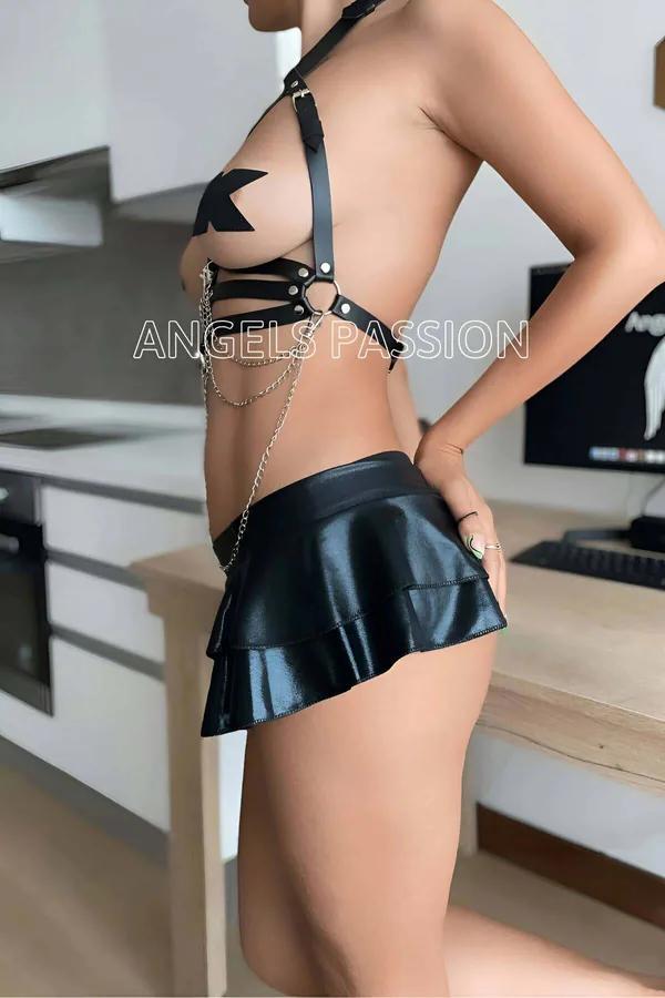 Siyah suni deri göğüs harness, gümüş O-ring ve sarkıt zincir detaylı, siyah mini etek kombinli