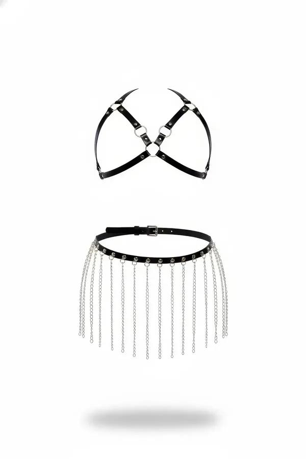 Black faux leather chest harness with silver O-rings and chain fringe skirt belt set flat lay on white background