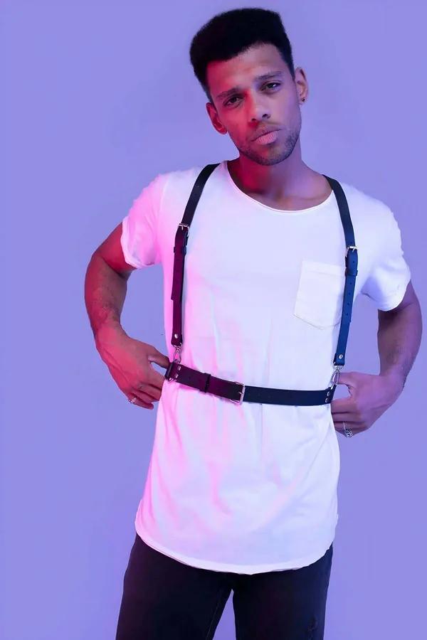 Black faux leather suspenders harness with silver buckles worn over white t-shirt, adjustable waistband