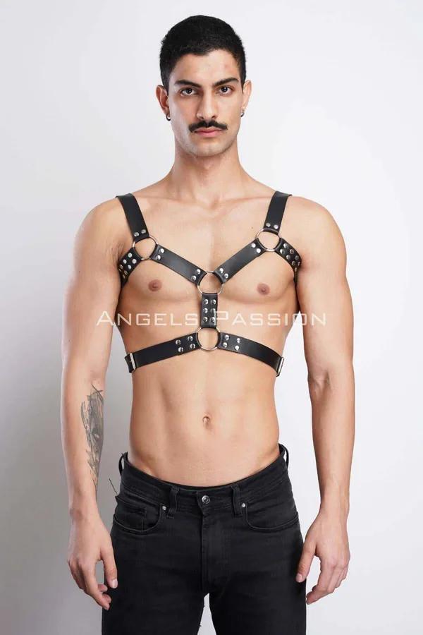 black faux leather chest harness with silver dome rivets and three O-rings worn front view